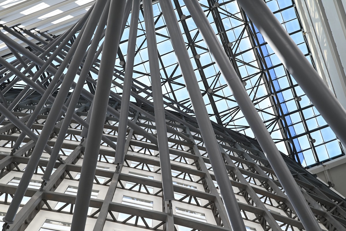Modern building interior with steel beams and glass ceiling, representing structural frameworks